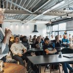 Palestrante apresenta propostas e ferramentas de tecnologia a um público durante um evento de inovação.