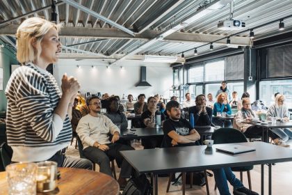 Palestrante apresenta propostas e ferramentas de tecnologia a um público durante um evento de inovação.
