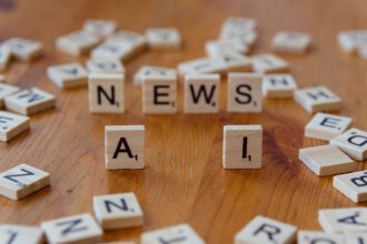 Peças de madeira formam as palavras “AI” e “NEWS” sobre uma superfície clara.
