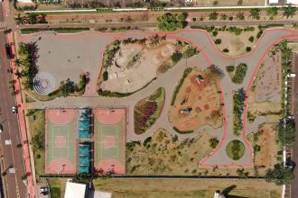 Vista aérea de um parque urbano colorido com quadras esportivas e áreas de recreação.