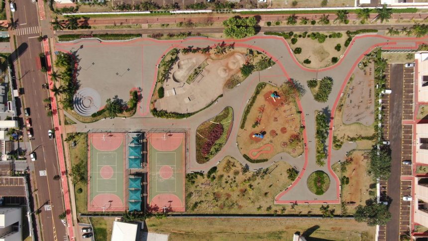 Vista aérea de um parque urbano colorido com quadras esportivas e áreas de recreação.